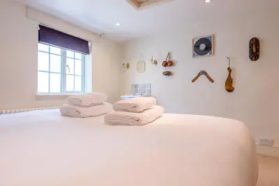 a bedroom with a large white bed with towels on it at Abigail's Cottage, Wickham Market in Woodbridge