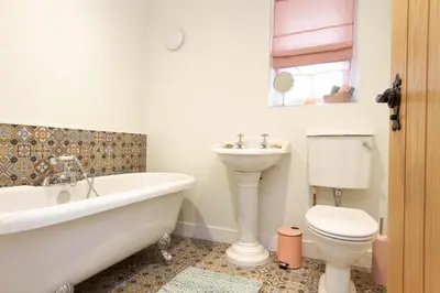a bathroom with a tub and a toilet and a sink at Breckland Cottage - Secluded Country Getaway in Hockwold cum Wilton