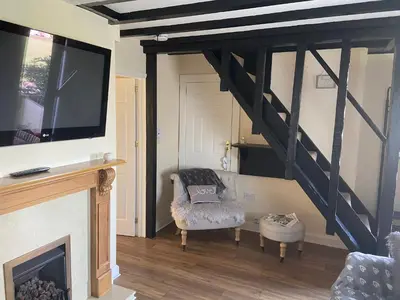 a living room with a fireplace and a tv at Cosy Cottage Great Bentley near station and shops in Great Bentley