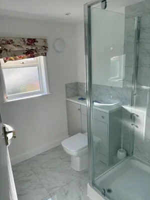 a bathroom with a toilet and a glass shower at Cosy Cottage Great Bentley near station and shops in Great Bentley