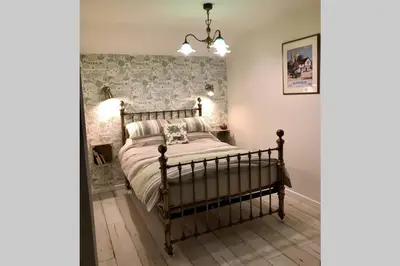 a bedroom with a bed and a wall at Melford Allotment Shed-Vintage Lodge Suffolk in Long Melford
