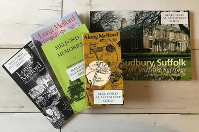 a pile of books sitting on top of a table at Melford Allotment Shed-Vintage Lodge Suffolk in Long Melford