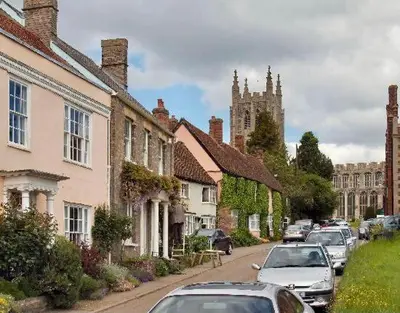 a row of houses on a street with cars parked at Melford Allotment Shed-Vintage Lodge Suffolk in Long Melford