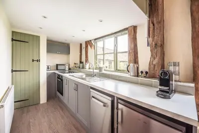 a kitchen with a sink and a counter top at Granary Cottage, Valley Farm, Snape in Saxmundham