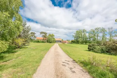 a dirt road in the middle of a field at Granary Cottage, Valley Farm, Snape in Saxmundham