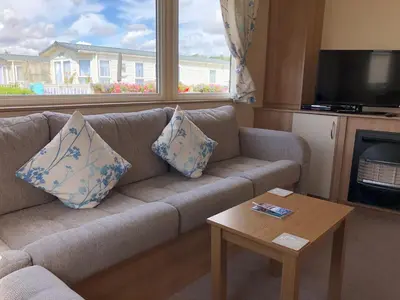 a living room with a couch and a table at Tref y Clawdd in Felixstowe