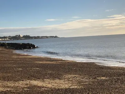 a beach with a rocky shoreline and the ocean at Tref y Clawdd in Felixstowe
