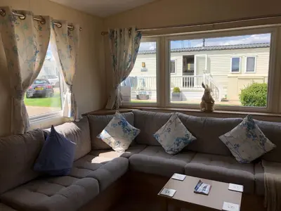 a living room with a couch and a window at Tref y Clawdd in Felixstowe