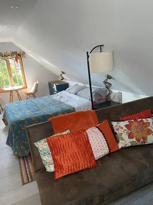 a bedroom with a bed and a couch with pillows at Foxgloves self catering in Westleton