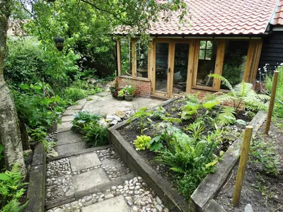 a garden with a path leading to a house at Foxgloves self catering in Westleton
