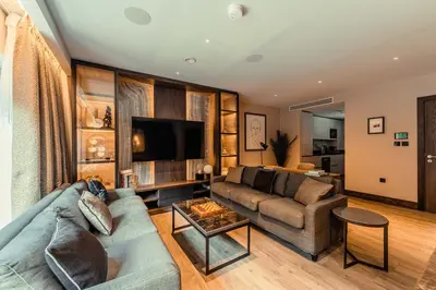 a living room with a couch and a tv at The Fellows House Mews in Cambridge