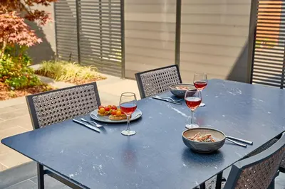 a blue table with wine glasses and a plate of food at The Fellows House Mews in Cambridge