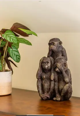 a statue of two chimpanzees sitting on a table next to a plant at The Cartlodge in Wickham Bishops