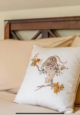 a pillow with a leopard on it sitting on a bed at The Cartlodge in Wickham Bishops