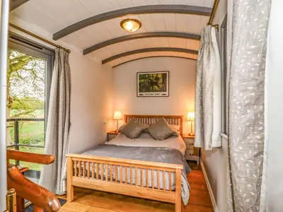 a bedroom with a bed and a window at The Carriage at High Barn Heritage in Halstead