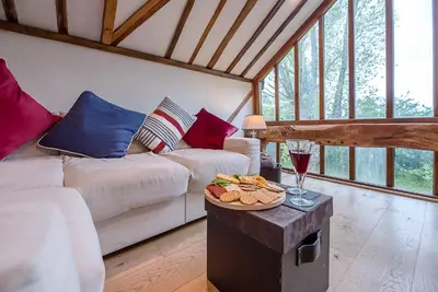 a living room with a couch and a table with a plate of food at The Hayloft, Clopton in Clopton