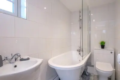 a white bathroom with a sink and a toilet at Foxes Lodge in Aldringham