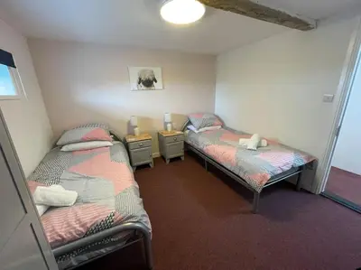 a room with two beds in a room at The Old Dairy Accommodation in Tillingham