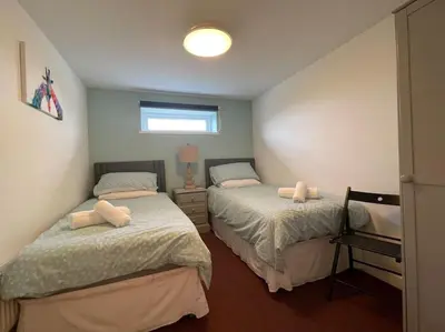 two beds in a small bedroom with a window at The Old Dairy Accommodation in Tillingham