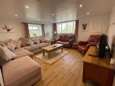 a living room with a couch and a table at The Old Dairy Accommodation in Tillingham