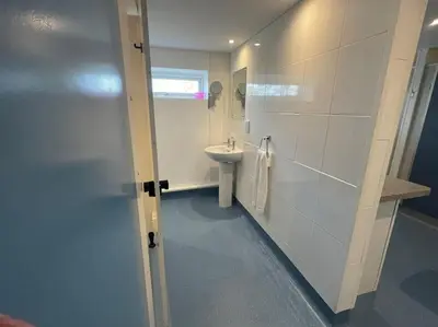 a white bathroom with a sink and a toilet at The Old Dairy Accommodation in Tillingham
