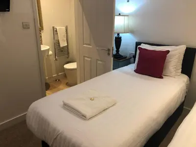 a bedroom with a white bed with a red pillow at Kings Hotel in Newmarket