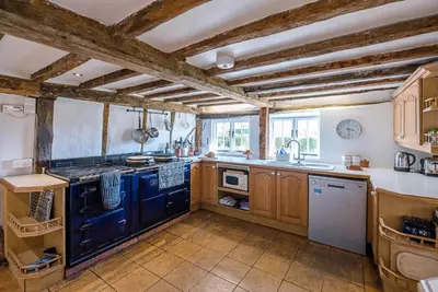 a large kitchen with blue appliances and wooden cabinets at Heart's Ease in Dallinghoo nr Woodbridge in Woodbridge