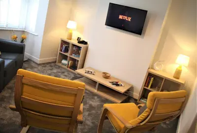 a living room with two chairs and a tv at The Alvaros Apartment in Southend-on-Sea