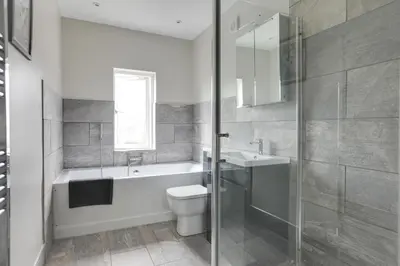 a bathroom with a tub and a toilet and a sink at Spacious Three Bedroom House - Free Parking & Wifi in Chelmsford