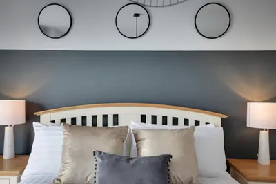 a bedroom with two mirrors above a bed with pillows at The Marina Penthouse in Ipswich