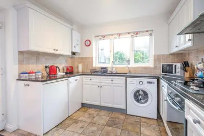 a kitchen with white cabinets and a washer and dryer at Bryony Cottage, 3 bedroom house in the seaside town of Aldeburgh - Aldeburgh Coastal Cottages in Aldeburgh