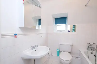 a white bathroom with a toilet and a sink at Bryony Cottage, 3 bedroom house in the seaside town of Aldeburgh - Aldeburgh Coastal Cottages in Aldeburgh