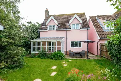 a pink house with a garden in front of it at Bryony Cottage, 3 bedroom house in the seaside town of Aldeburgh - Aldeburgh Coastal Cottages in Aldeburgh