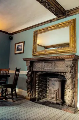 a fireplace with a mirror on top of it at The Marlborough Dedham in Dedham