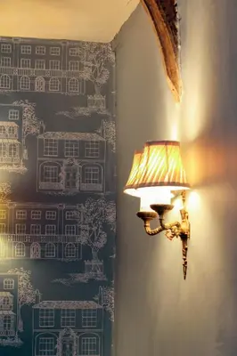 a lamp in a room with a wall with wallpaper at The Marlborough Dedham in Dedham