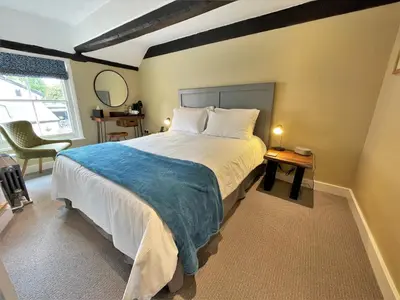 a bedroom with a large bed and a mirror at The Marlborough Dedham in Dedham