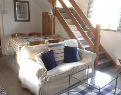 a living room with a white couch with blue pillows at Dairy Cottage in Cockley Cley