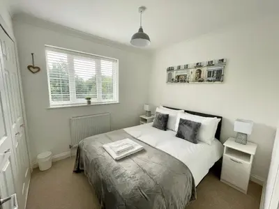 a white bedroom with a bed and a window at Number 15 in Norwich