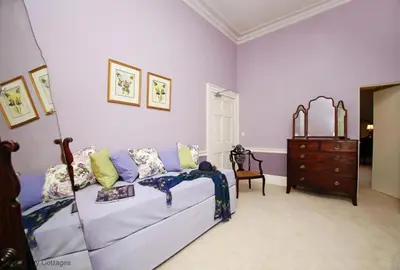 a purple bedroom with a bed and a dresser at Bressingham Hall in Bressingham