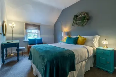 a blue bedroom with a bed and a desk at The Anchor in Sutton