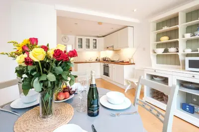 a kitchen with a table with a vase of flowers at 201 High Street in Aldeburgh