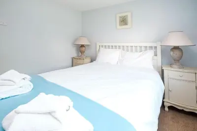 a bedroom with a white bed with towels on it at 201 High Street in Aldeburgh