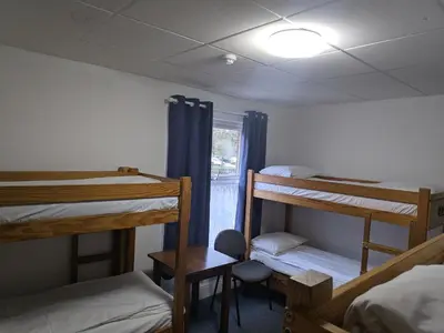 a room with three bunk beds and a window at HARLOW INTERNATIONAL HOSTEL in Harlow