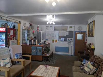 a living room filled with furniture and a refrigerator at HARLOW INTERNATIONAL HOSTEL in Harlow