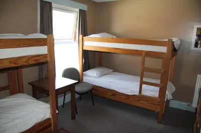a room with three bunk beds and a window at HARLOW INTERNATIONAL HOSTEL in Harlow