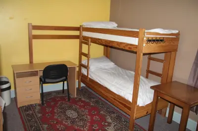 two bunk beds in a room with a desk and a chair at HARLOW INTERNATIONAL HOSTEL in Harlow