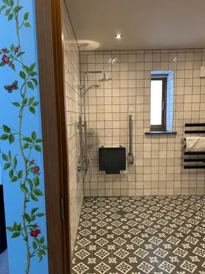a bathroom with a shower with a tiled floor at Guinness Arms in Icklingham