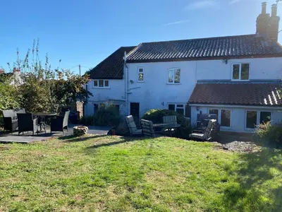 a house with a yard with chairs and a table at Carlton Cottage Country Retreat - Perfect for Ipswich - Aldeburgh - Southwold - Thorpeness - Sizewell B - Sizewell C - Sleeps 13 in Little Glenham