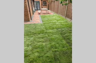 a small yard with green grass and a fence at The Bungalow in Chesterton