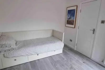 a white bedroom with a bed and a closet at The Bungalow in Chesterton